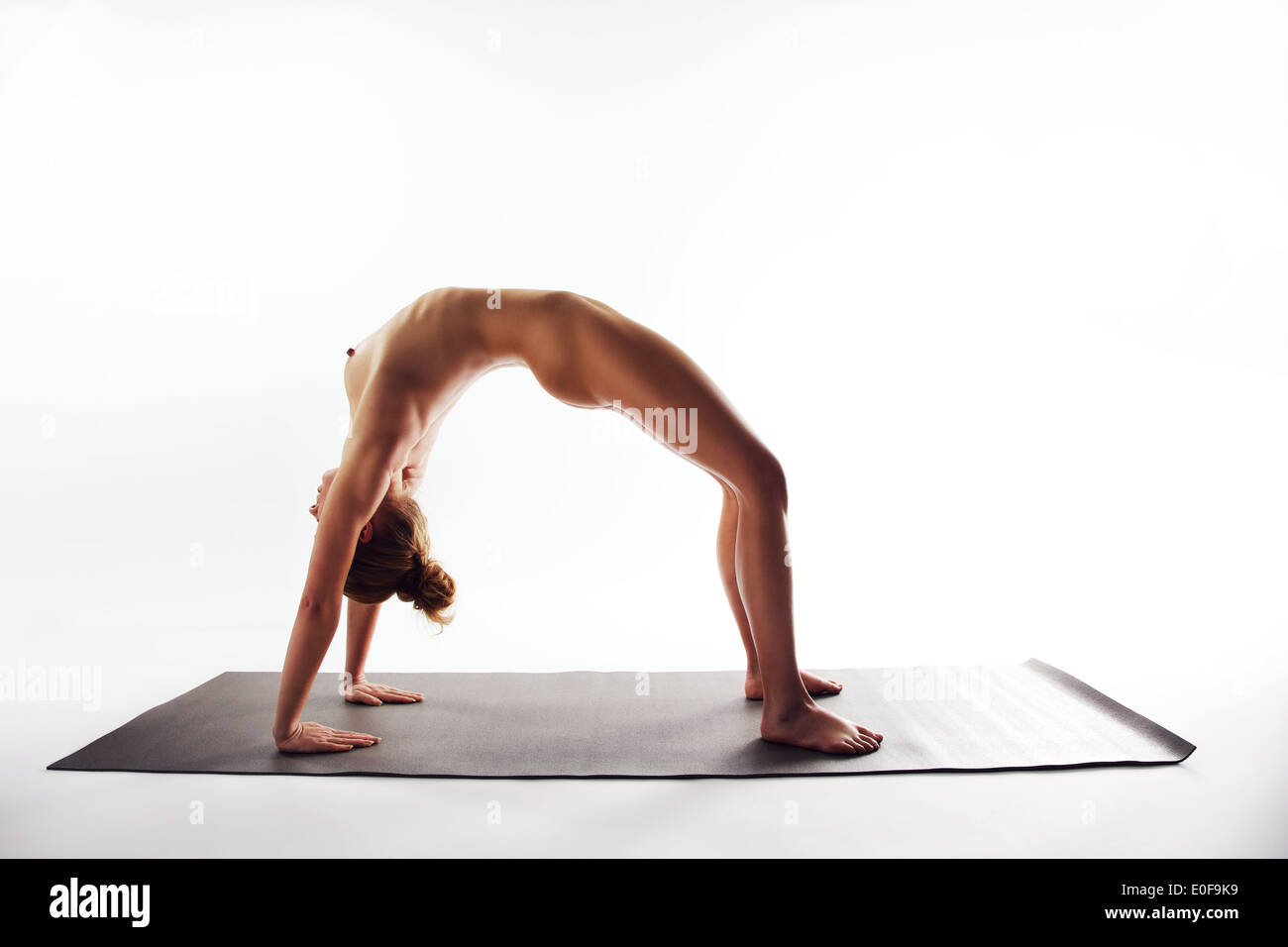 Beautiful Young Naked Woman Arching Her Back On Yoga Mat Over