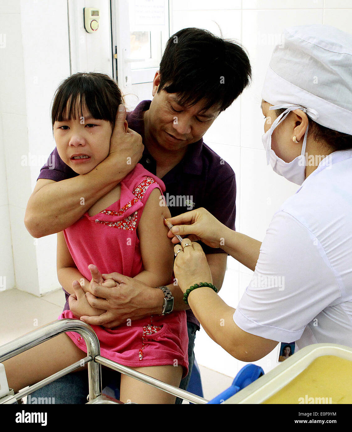 Hanoi, Vietnam. 12th May, 2014. A girl is vaccinated against measles in Hanoi, capital of Vietnam, May 12, 2014. Hanoi medical authority organized measles vaccination for some 50,000-60,000 children aged 2-10 years old from May 12 to 16. According to statistics by Vietnam's Ministry of Health, by April 15, 2014, the country reported over 3,000 measles cases in 61 out of 63 provinces and cities. © VNA/Xinhua/Alamy Live News Stock Photo