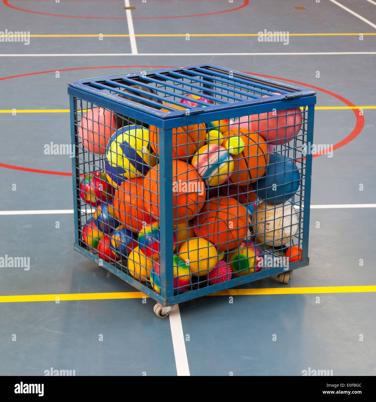 Collection of different balls in a metal cage, school gym Stock Photo