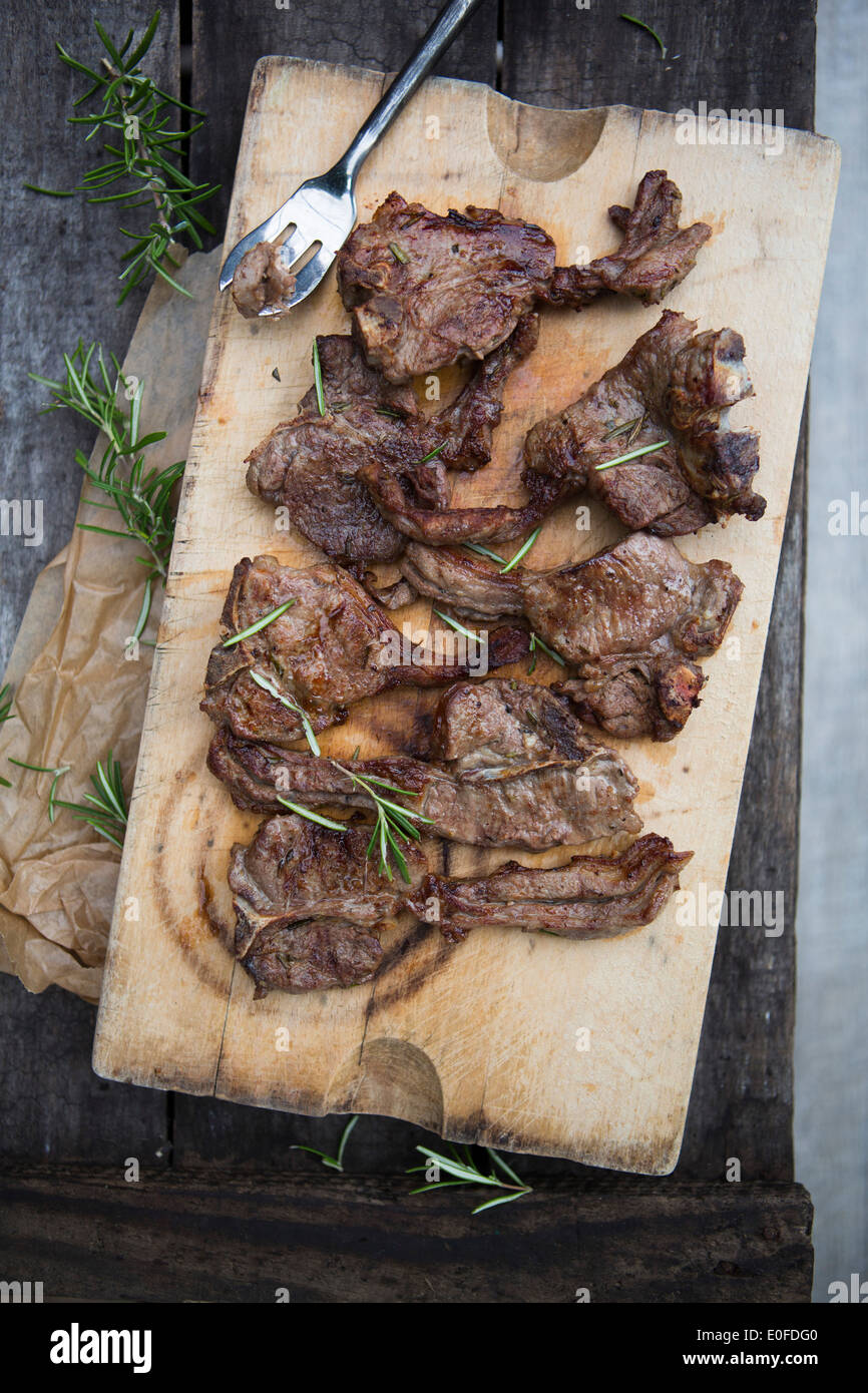 Lamb Chops with Rosemary on a board with fork Stock Photo