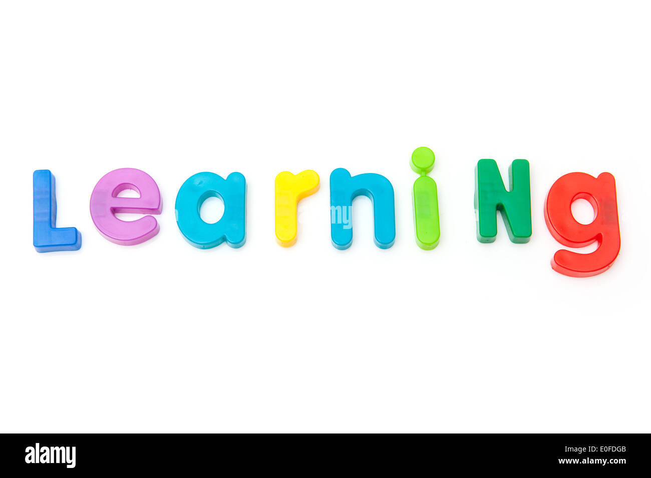 Learning written in magnetic letters. on a white studio background. Stock Photo