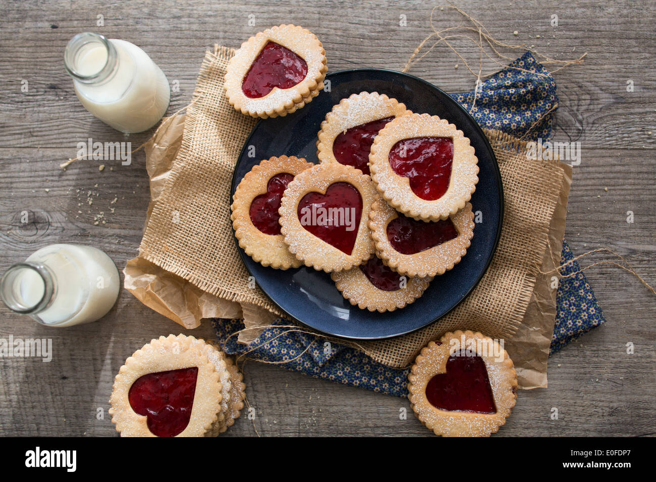 Strawberry Jam, heart shaped Linzer Biscuits on a plate with milk bottles Stock Photo