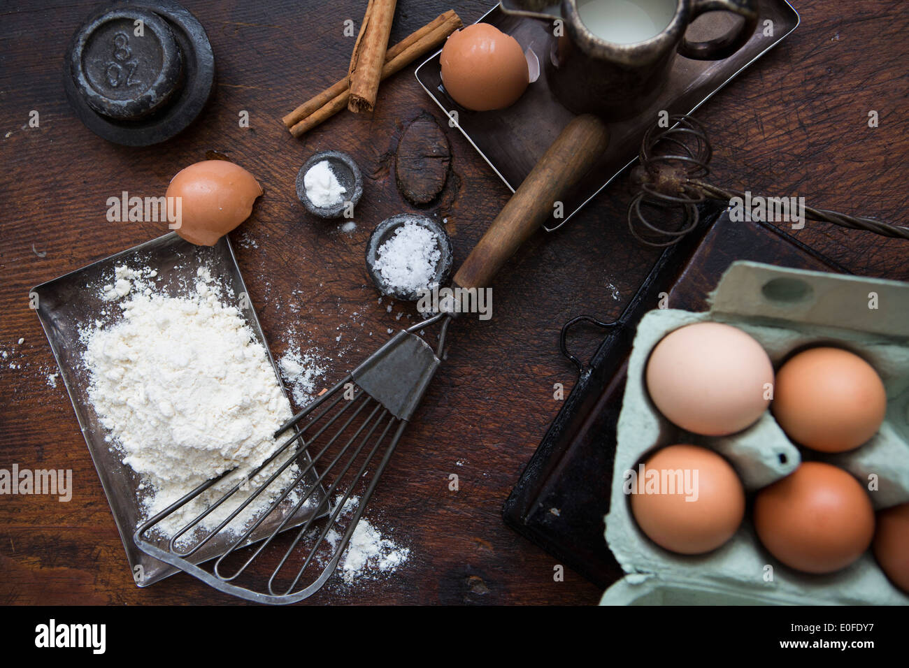 Ingredients for making pancakes, including eggs, flour cinnamon and a batterwhip Stock Photo
