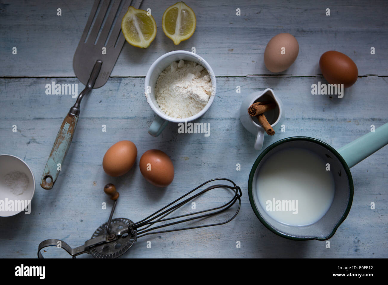 Ingredients for making pancakes, including eggs, flour cinnamon and a batterwhip Stock Photo