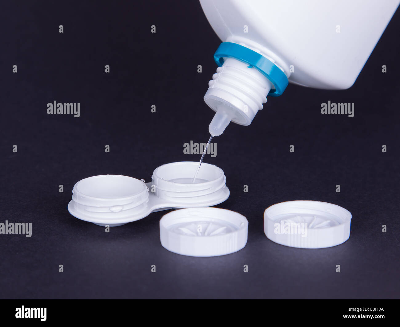 Lens casing and bottle of water isolated on black, contact lenses Stock