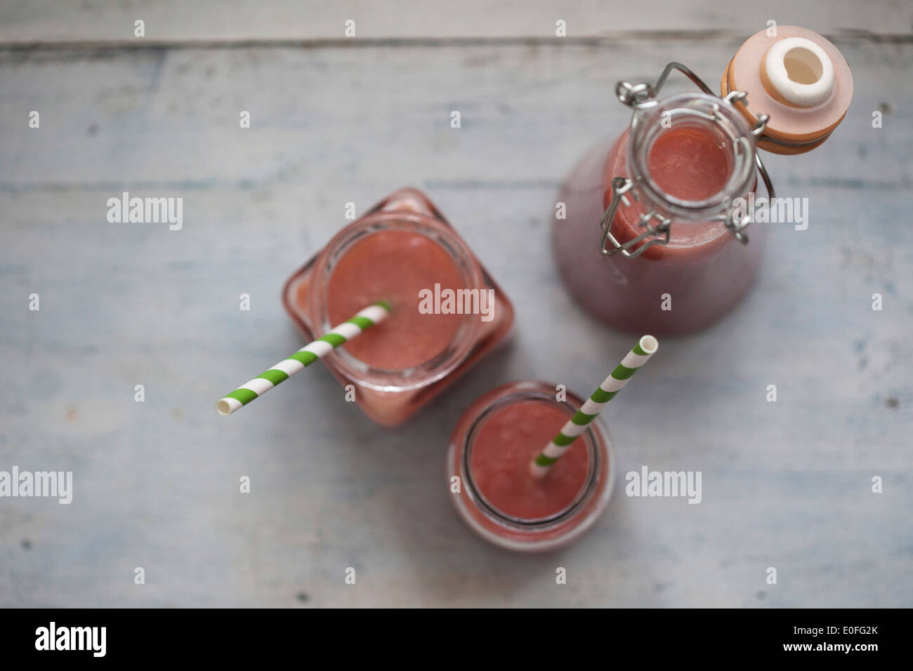 Strawberry Smoothies in jars with stripy straws Stock Photo
