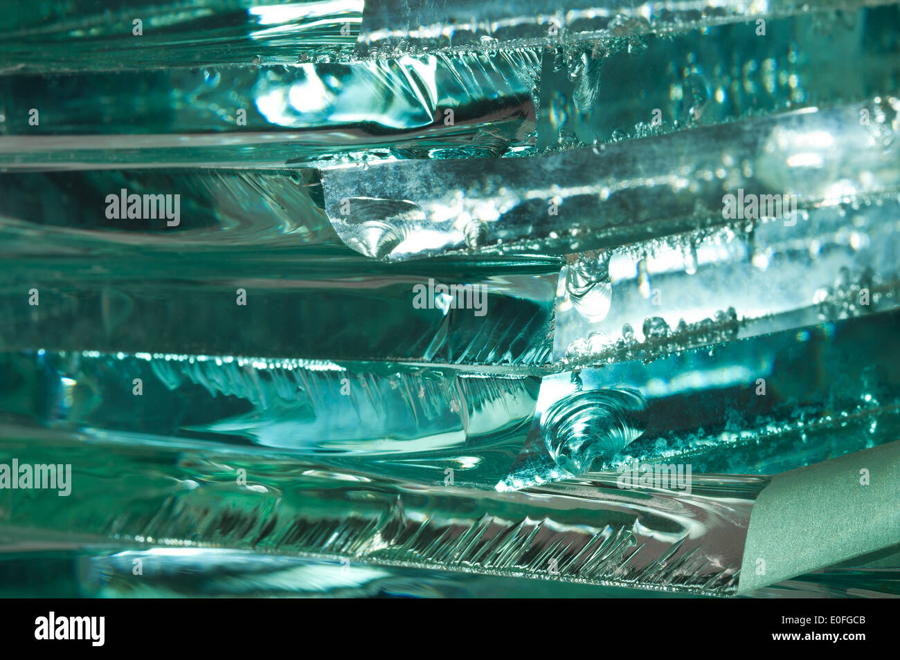 Sharp dangerous edge of plate glass internal reflection brings out green color and depth Stock