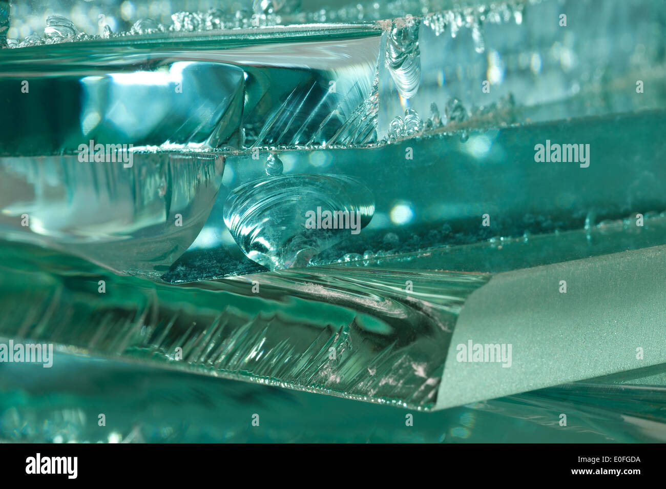 Sharp dangerous edge of plate glass internal reflection brings out green color and depth Stock