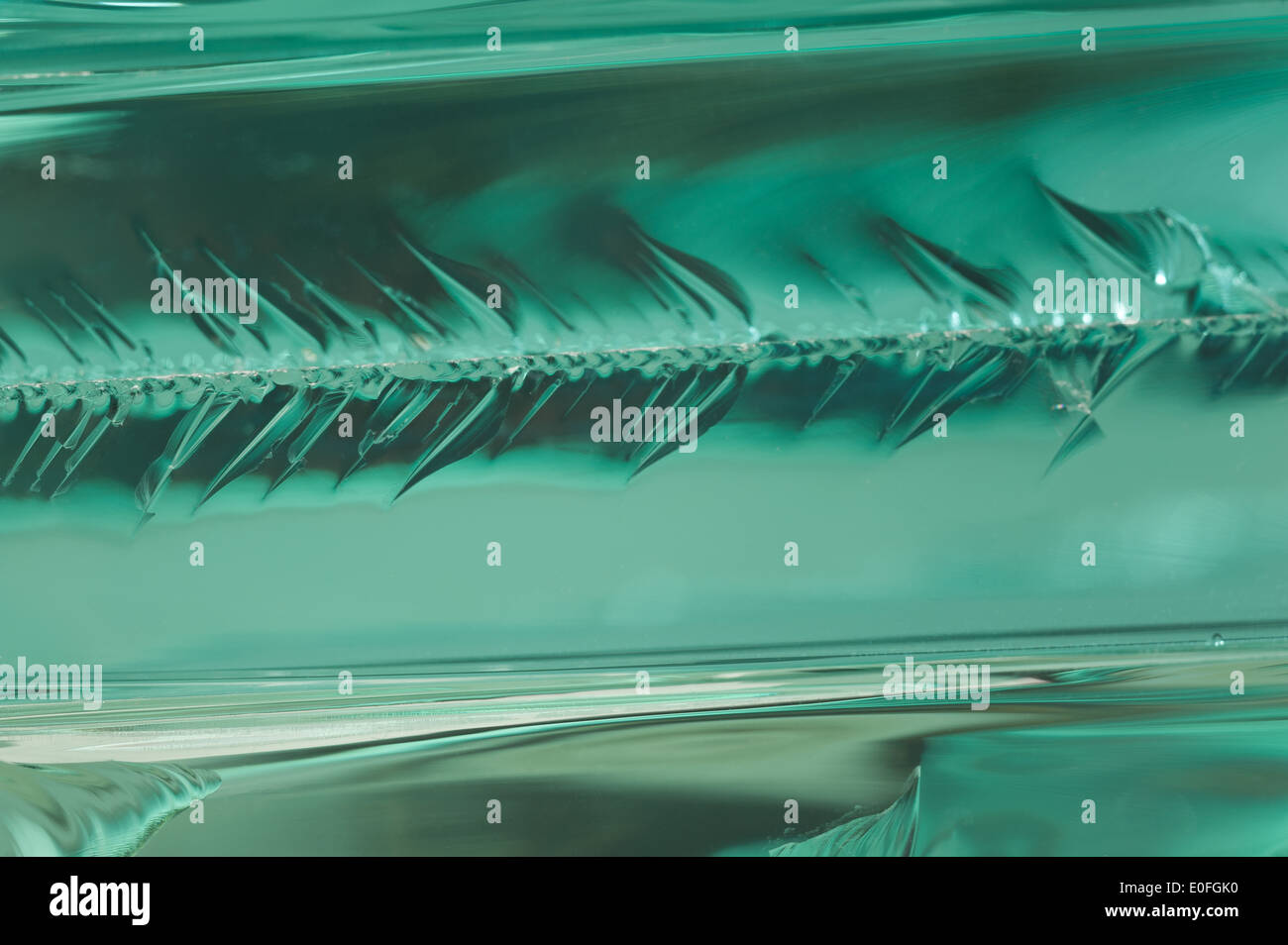 Sharp dangerous edge of plate glass internal reflection brings out green color and depth Stock