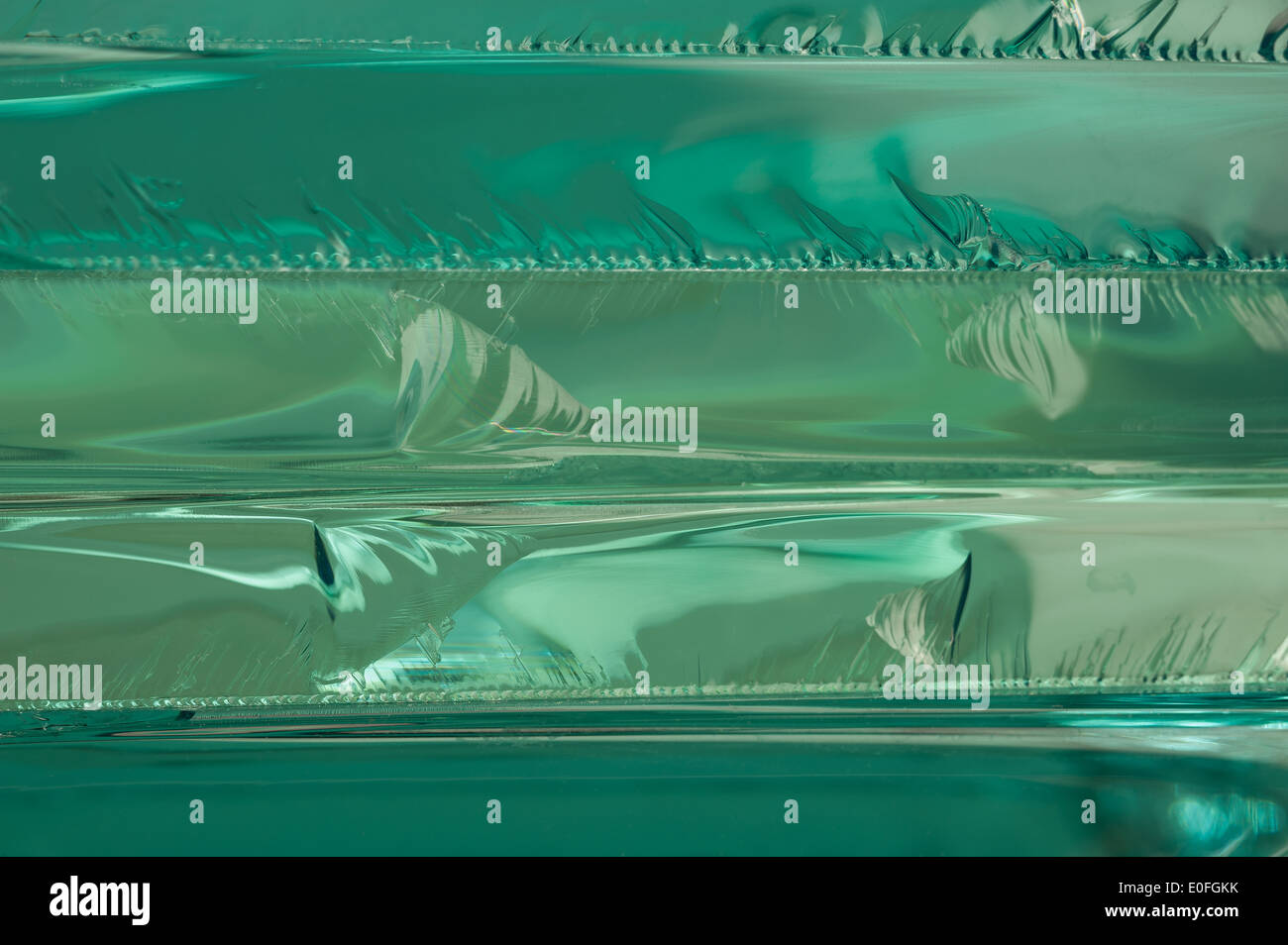 Sharp dangerous edge of plate glass internal reflection brings out green color and depth Stock