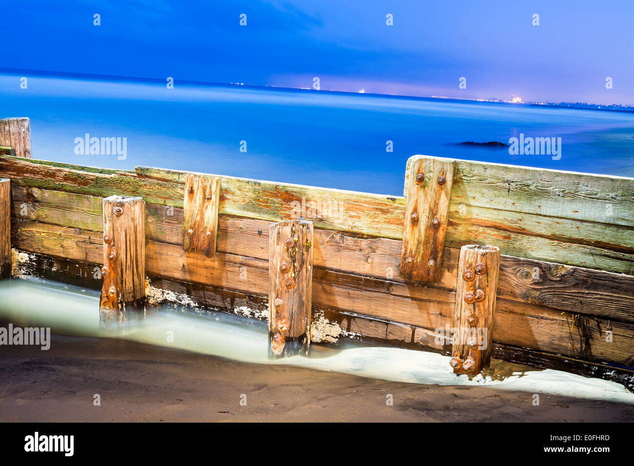 A beautiful image of a light painted wooden break wall shot before dawn with a long exposure. Stock Photo