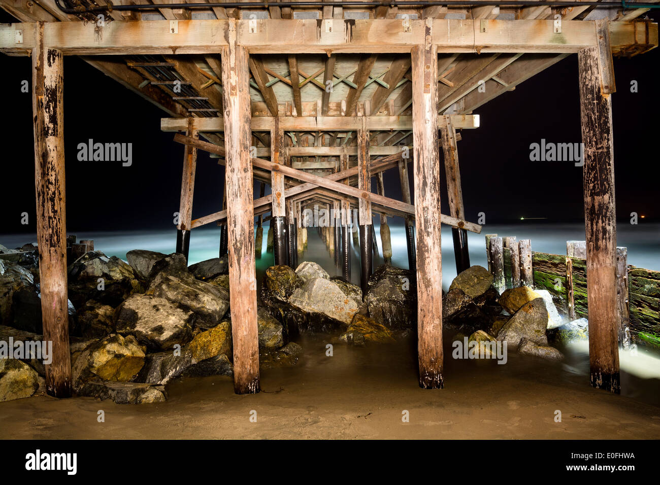A light painted image of Balboa Pier underside taken at 4:00 AM with a slow exposure shows the intricate detail of the structure Stock Photo