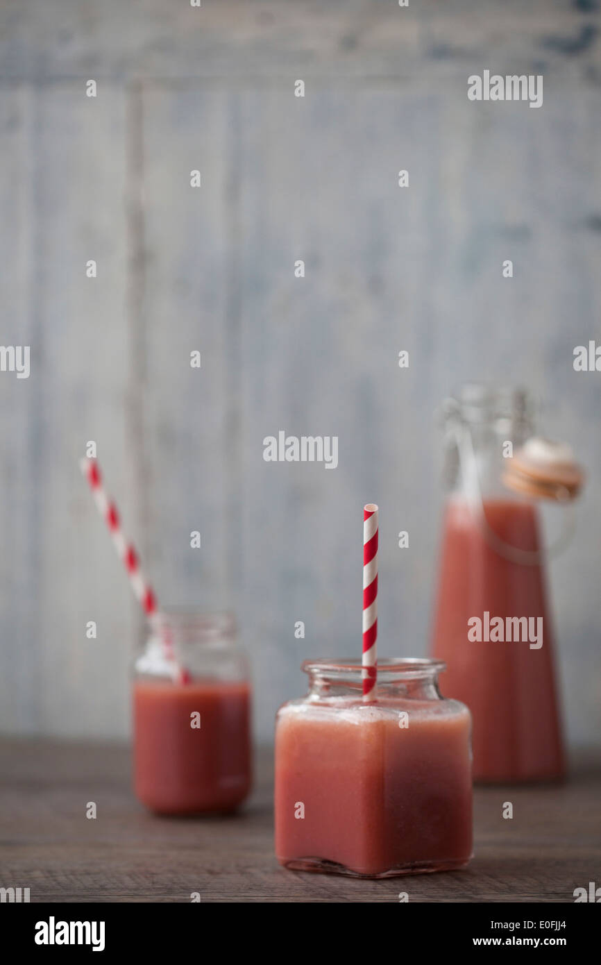 Strawberry Smoothies in jars with stripy straws Stock Photo