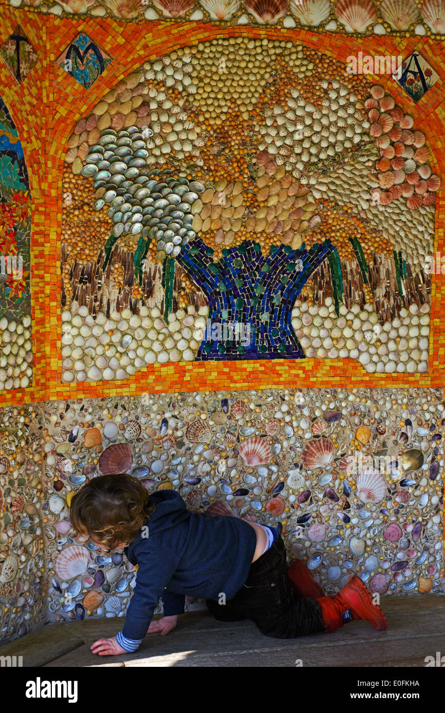 young child looking closely at the shells in the shell mosaic, shell house, shell grotto at Abbey Gardens Tresco, Isles of Scilly, Scillies, Cornwall Stock Photo