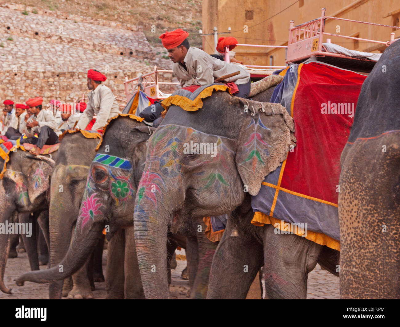Mahouts and their elephants waiting to convey tourists up a steep incline to the 16th century Amber fortress in Rajasthan, India Stock Photo