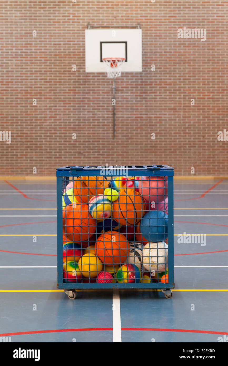 Collection of different balls in a metal cage, school gym Stock Photo