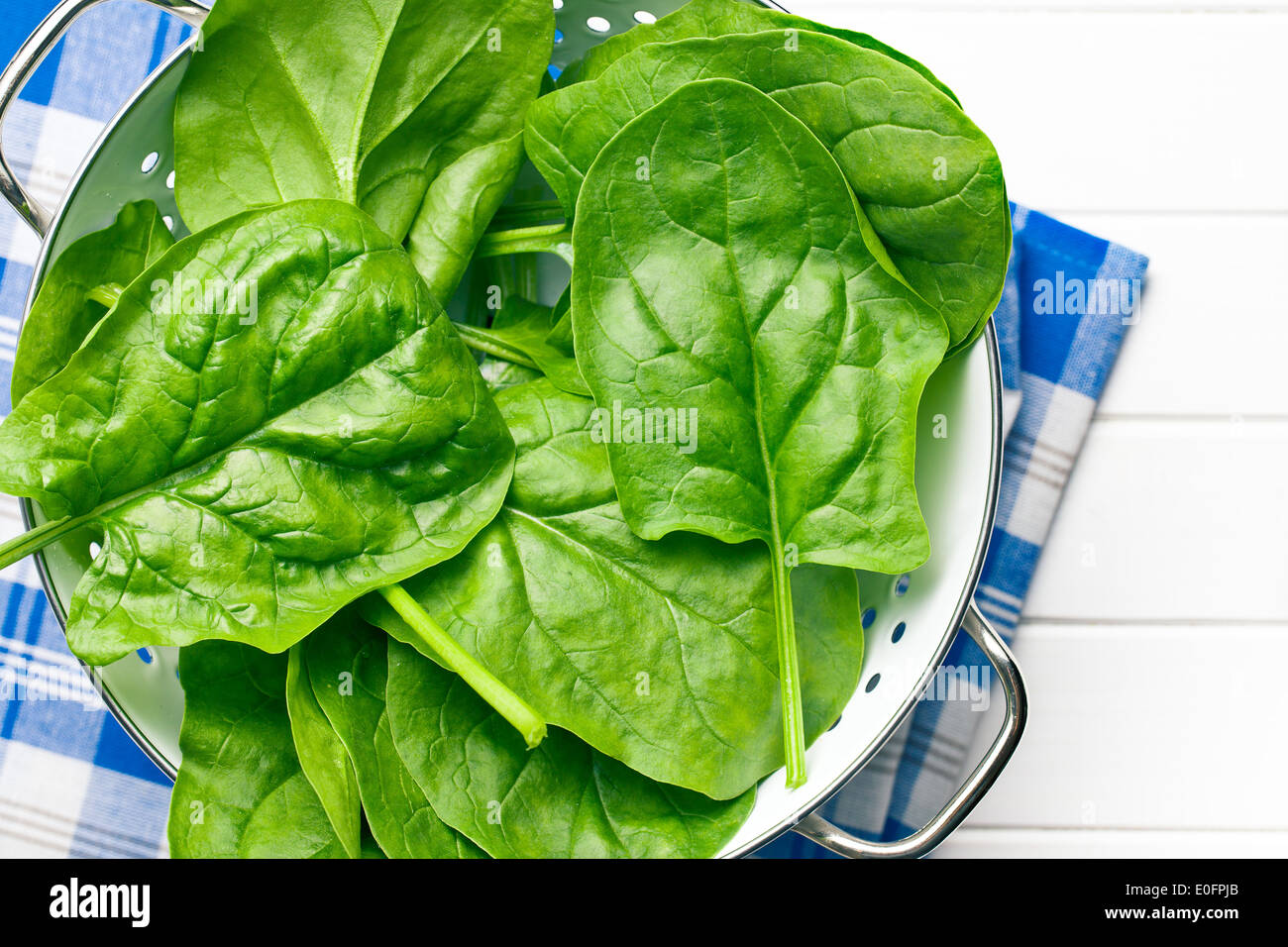 top view of green spinach leaves in colander Stock Photo