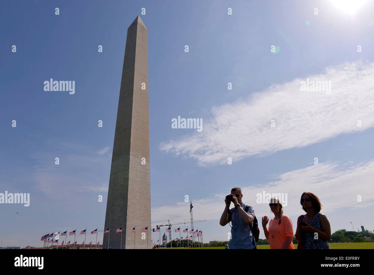 Washington, DC, USA. 12th May, 2014. Visitors stand in front of the Washington Monument during a reopening ceremony, in Washington, DC, the United States, on May 12, 2014. The iconic Washington Monument in this American national capital on Monday reopened on completion of 32-month repairs with a cost of 15 million U.S. dollars. Credit:  Yin Bogu/Xinhua/Alamy Live News Stock Photo