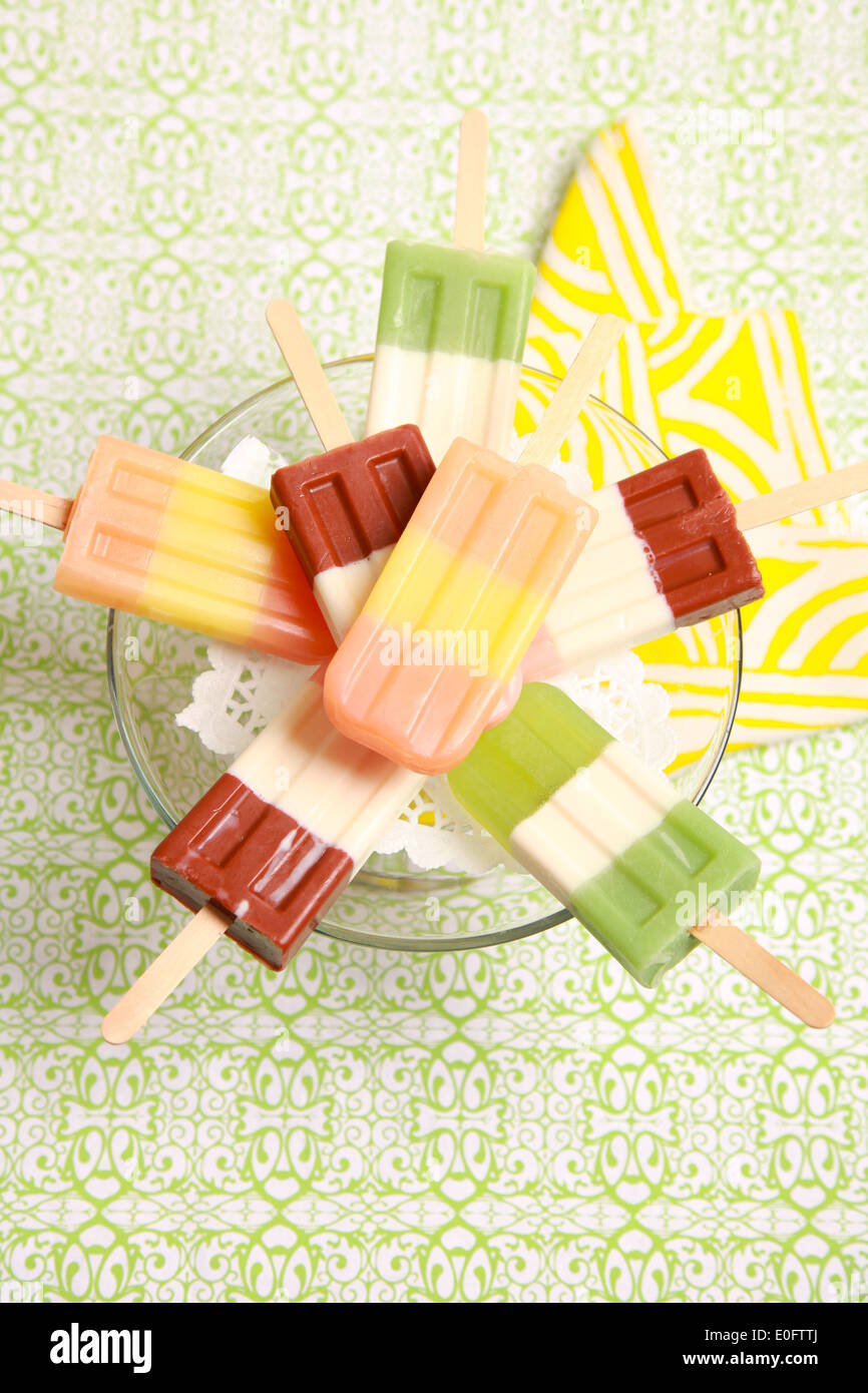 Birdseye view of 6 popsicle-shaped soaps on a clear tray with yellow napkin below. Stock Photo