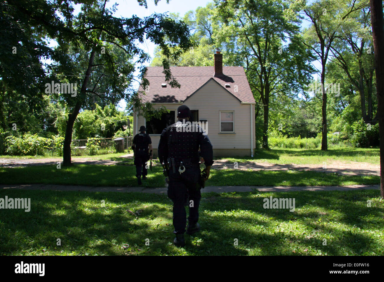 Detroit Police Narcs - Narcotics officers - appraoch a house raided for drugs, Detroit, Michigan, USA Stock Photo