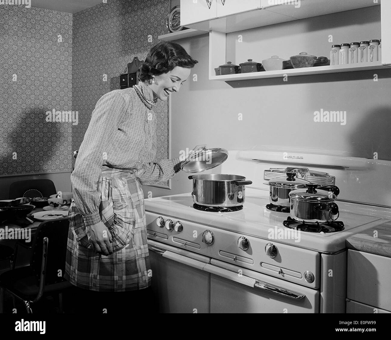 [Actress at Stove, Motion Picture Kitchen Set, Texas-Illinois Co.] Stock Photo