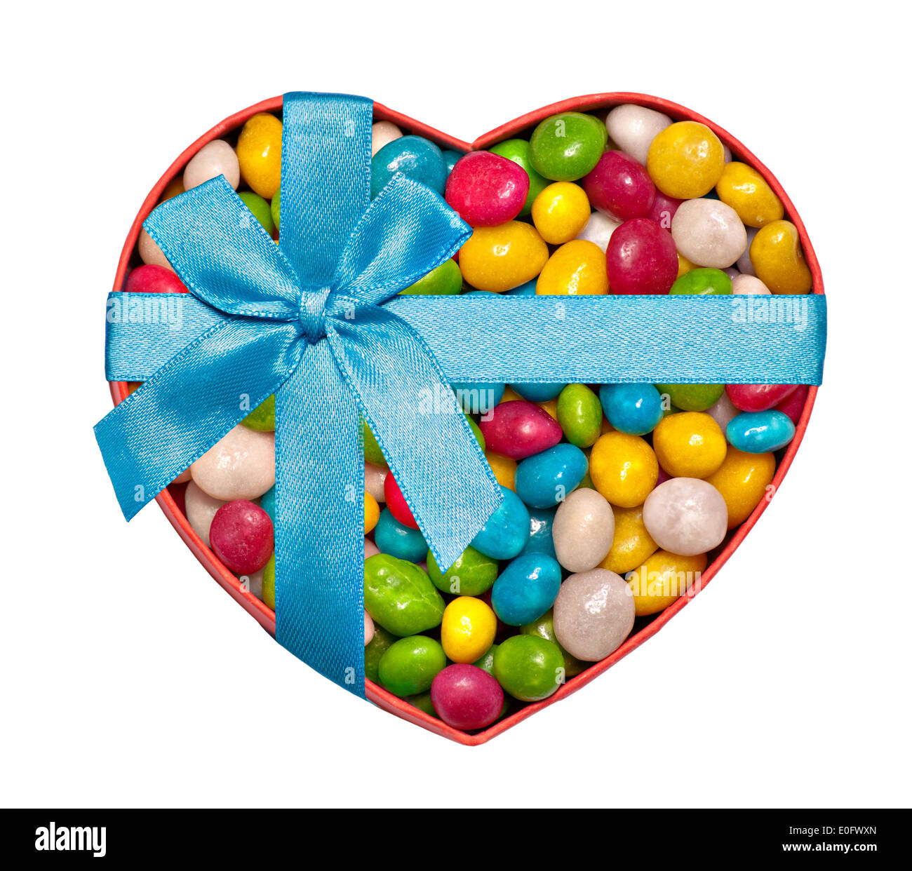 Heart-shaped box filled with colorful candies and tied with blue ribbon and bow Stock Photo