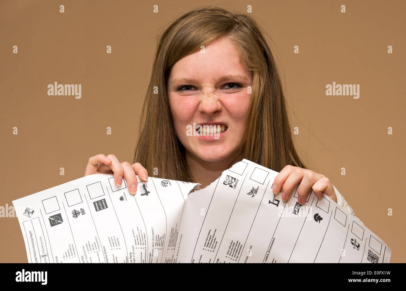 Angry young voting tearing ballot paper with spoiled voting paper Stock Photo