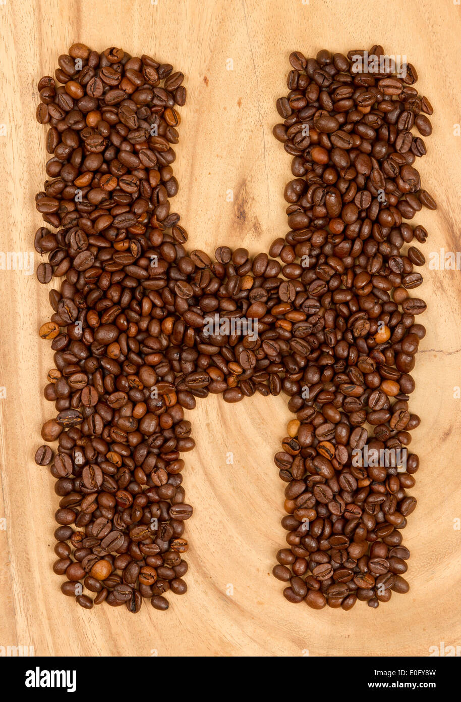 Letter H, alphabet from coffee beans. isolated on wood Stock Photo