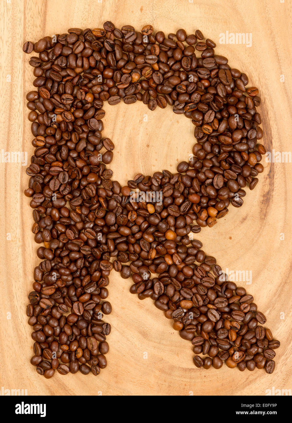 Letter R, alphabet from coffee beans. isolated on wood Stock Photo