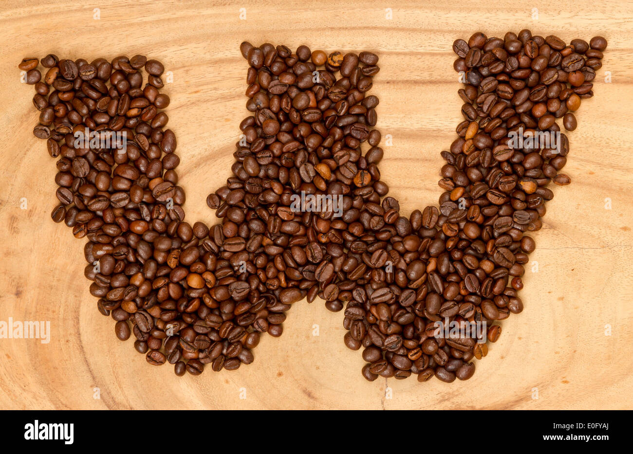 Letter W, alphabet from coffee beans. isolated on wood Stock Photo