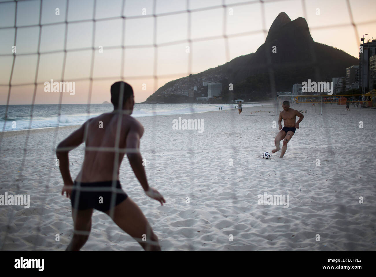 Brazilian men playing football on Ipanema beach in Rio de Janeiro Stock Photo