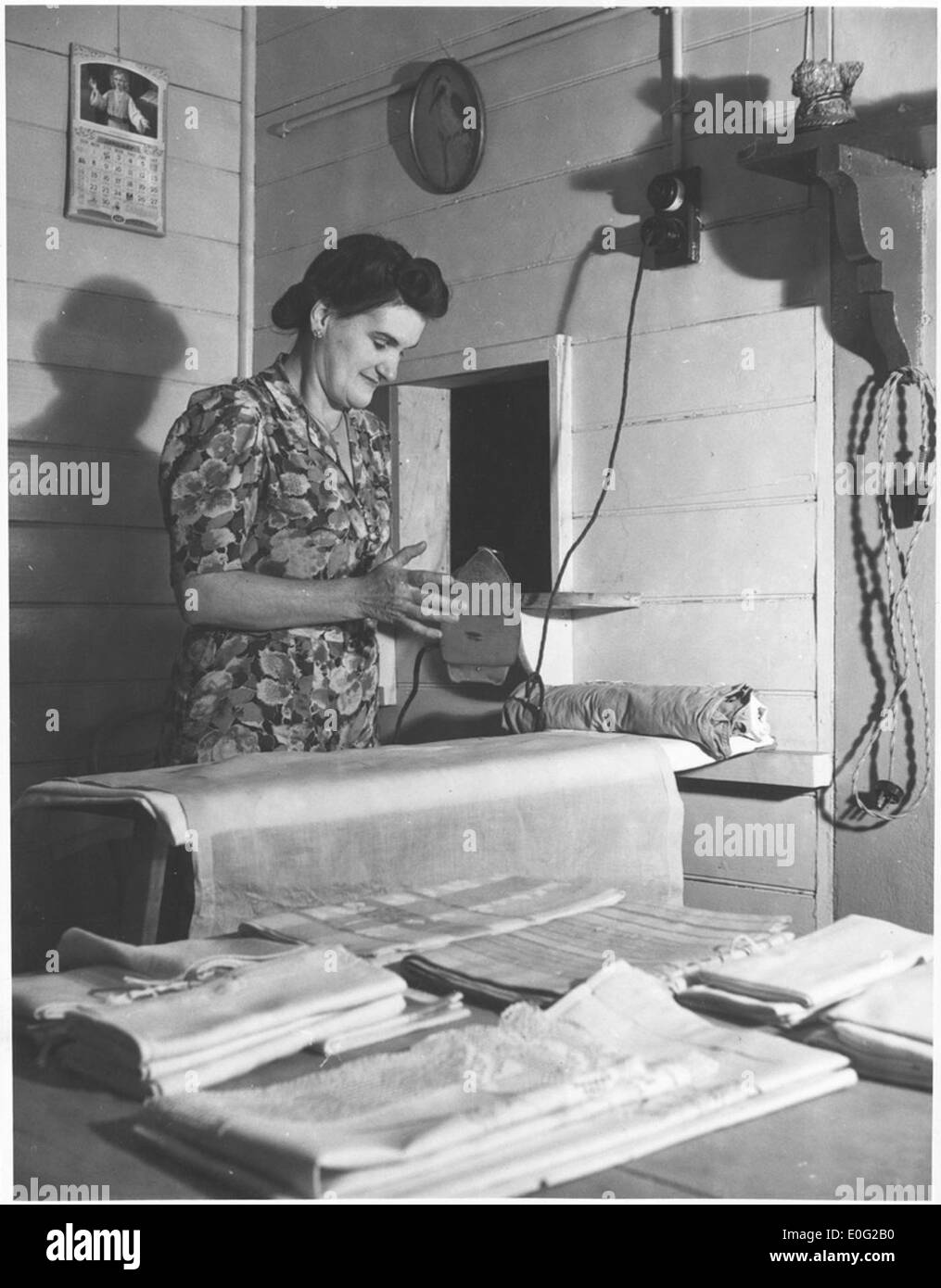Vanice Sullivan, wife of the Station Master, testing the heat of her iron, Drouin, Victoria, ca. 1944 Stock Photo