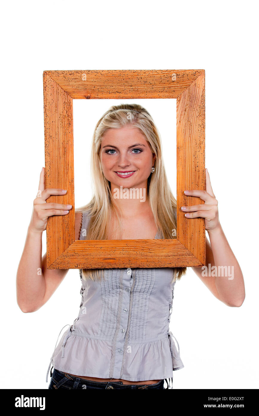 Young woman sees by a picture frame., Junge Frau sieht durch einen Bilderrahmen. Stock Photo