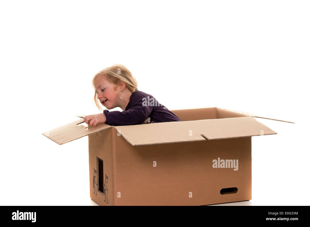 Child in move cardboard. Lies with the move in box., Kind in Umzugskarton. Liegt beim Umzug in Schachtel. Stock Photo
