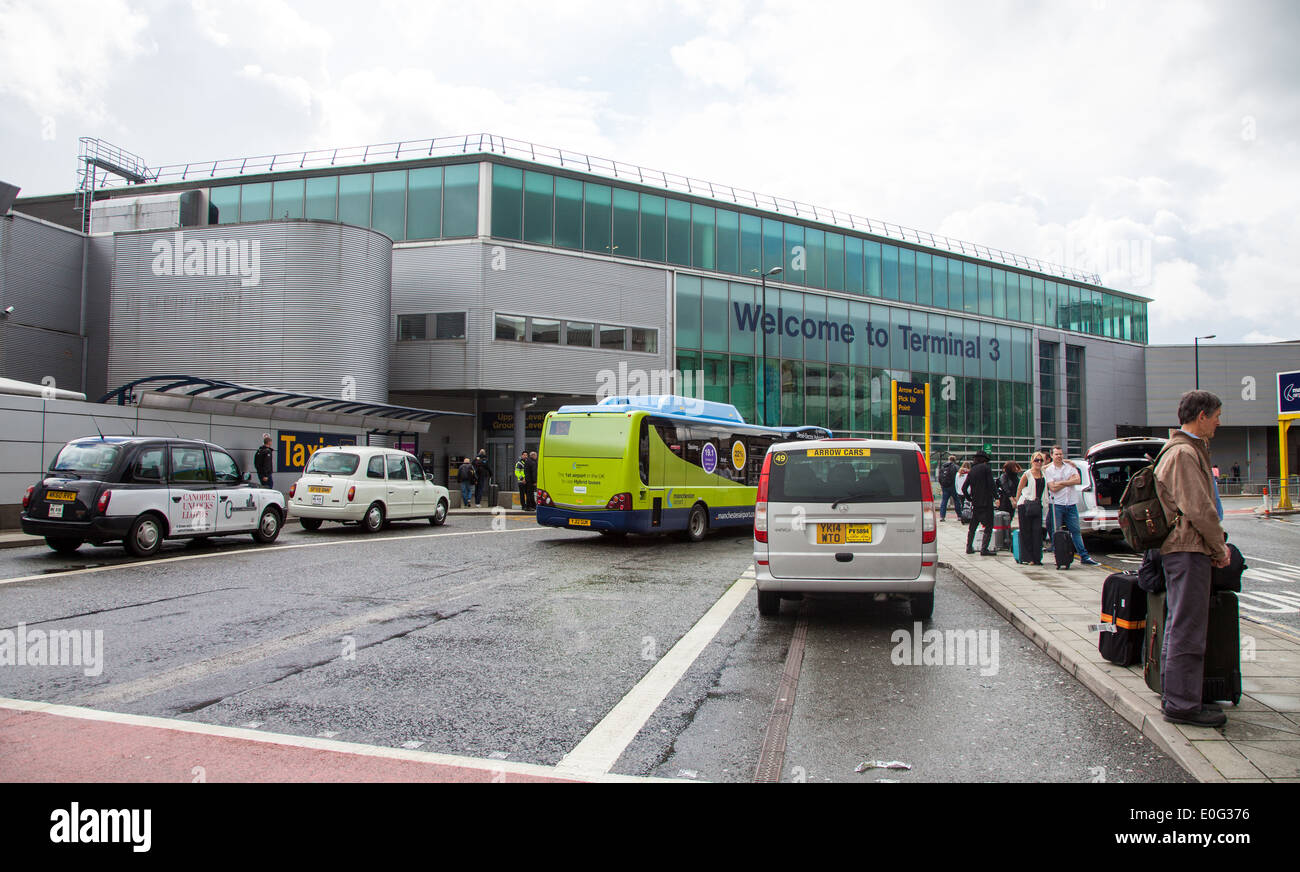 Taxis and buses dropping off people at Terminal Three of Manchester Airport England UK Stock Photo