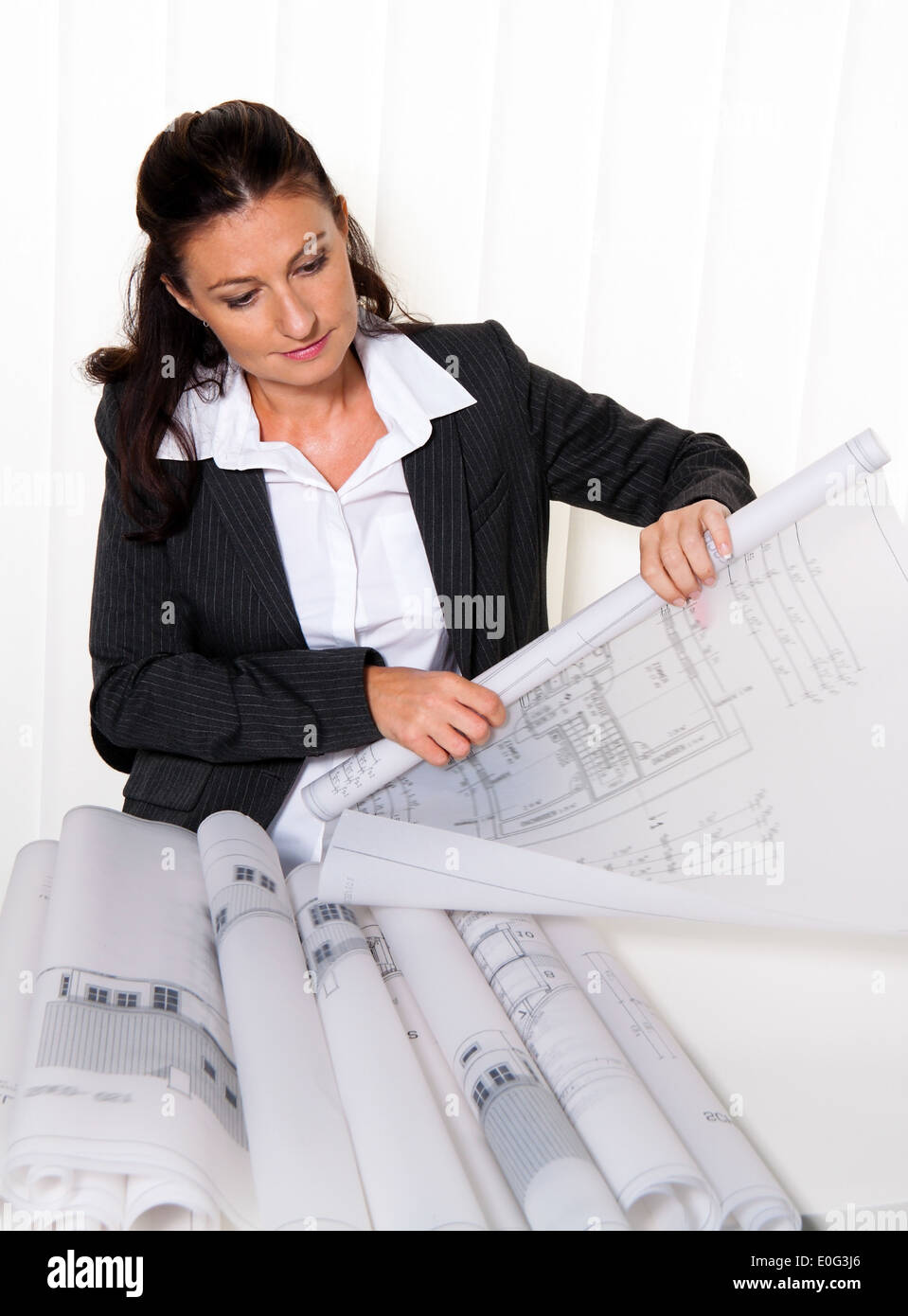Architect with architect's plan in the office. Plans of a dwelling house are worked on, Architekt mit Bauplan im Buero. Plaene e Stock Photo