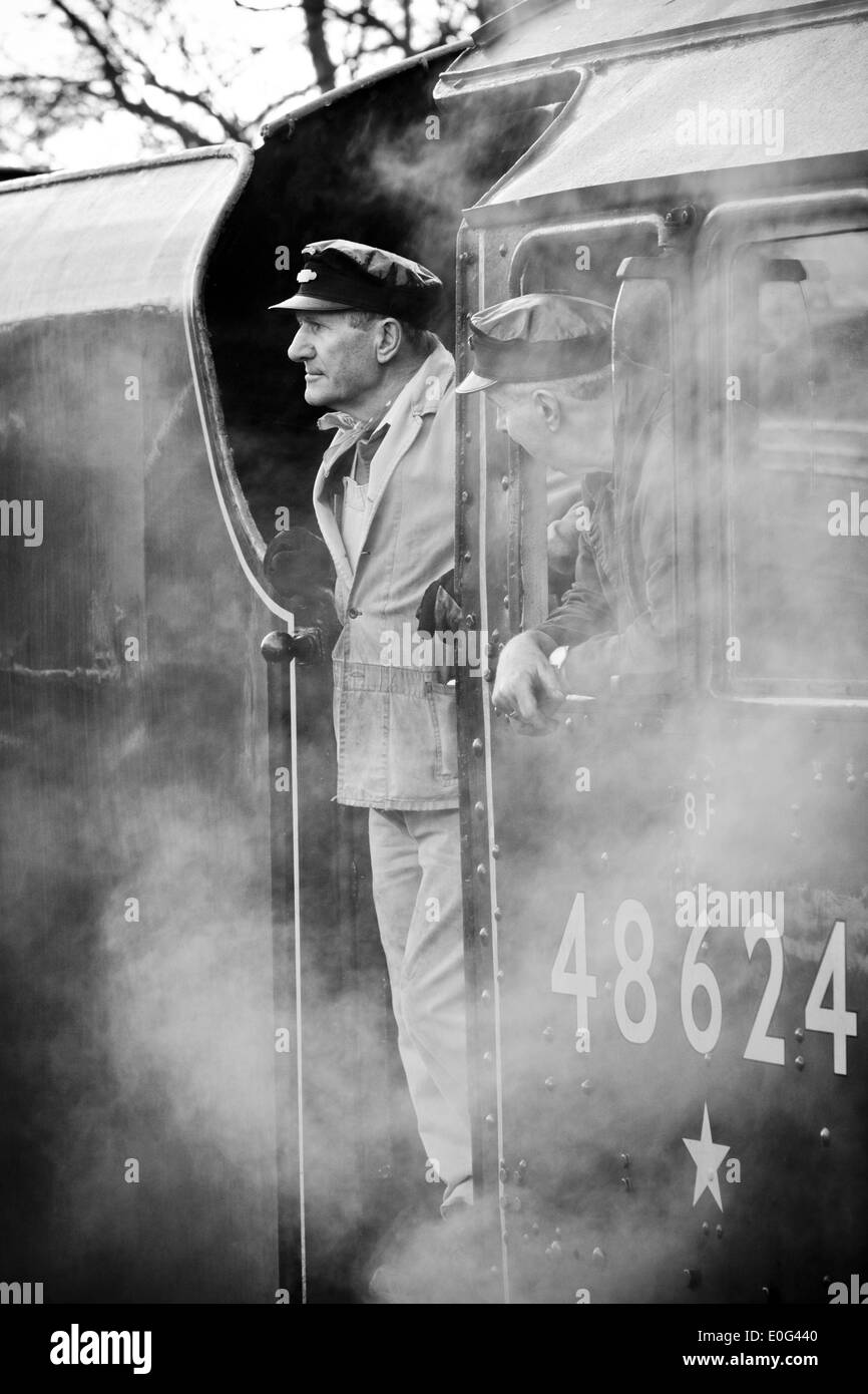 A steam engine driver looking out of his engine on the Great Central Railway at Rothley in Leicestershire Stock Photo