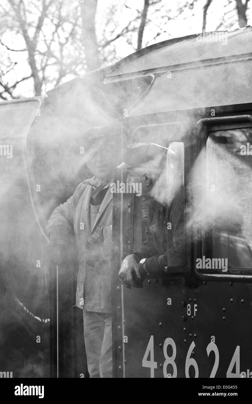 Two steam engine drivers looking out of their engine on the Great Central Railway at Rothley in Leicestershire Stock Photo