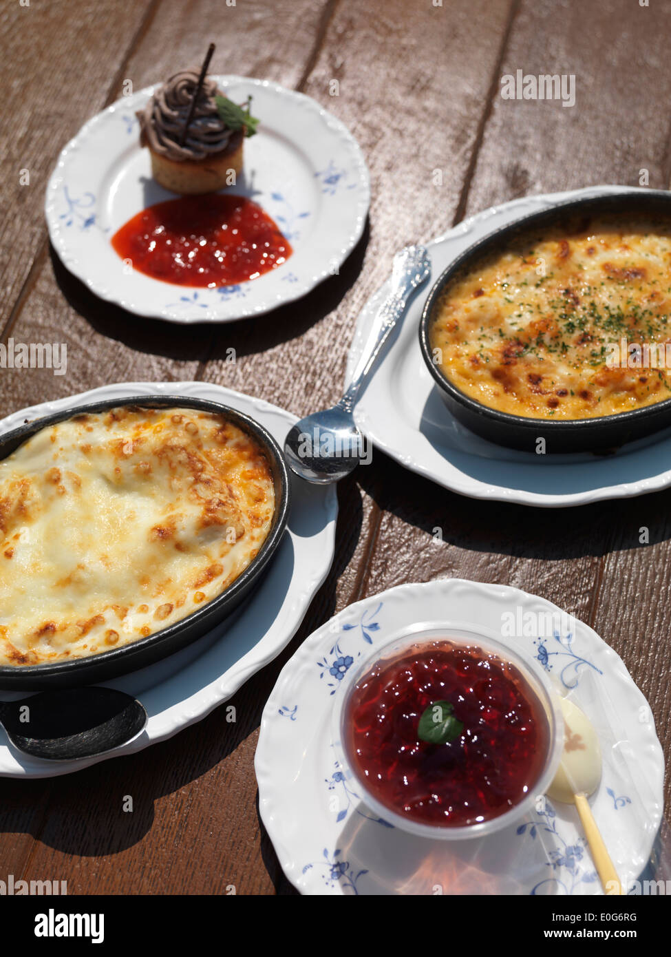Lasagna, casserole dish and desserts on a table at Italian restaurant Stock Photo
