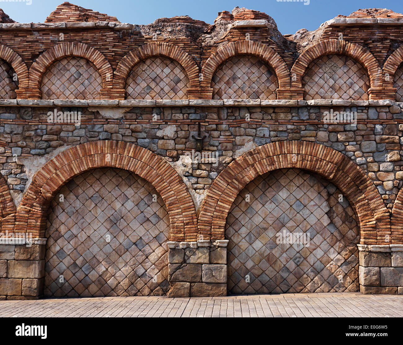 Old stone wall with brick arches antique rustic architectural texture Stock Photo