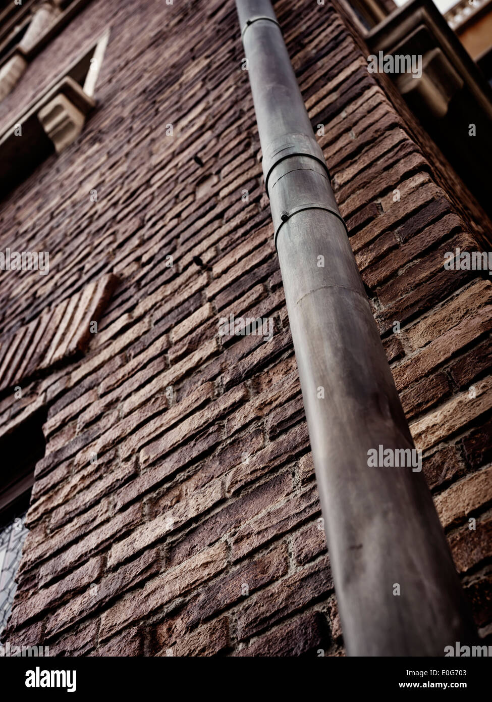 Closeup of a rustic copper downspout of old brick building Stock Photo