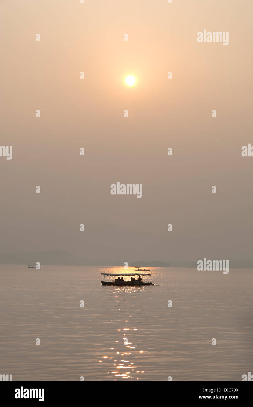 Sunset and boat silhouette, West Lake, Hangzhou, China Stock Photo