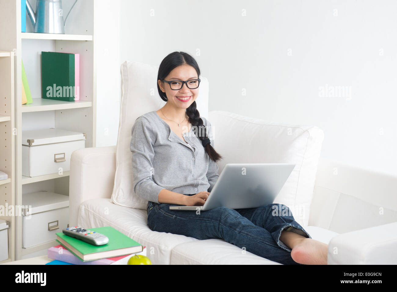young asian girl using laptop on sofa Stock Photo - Alamy