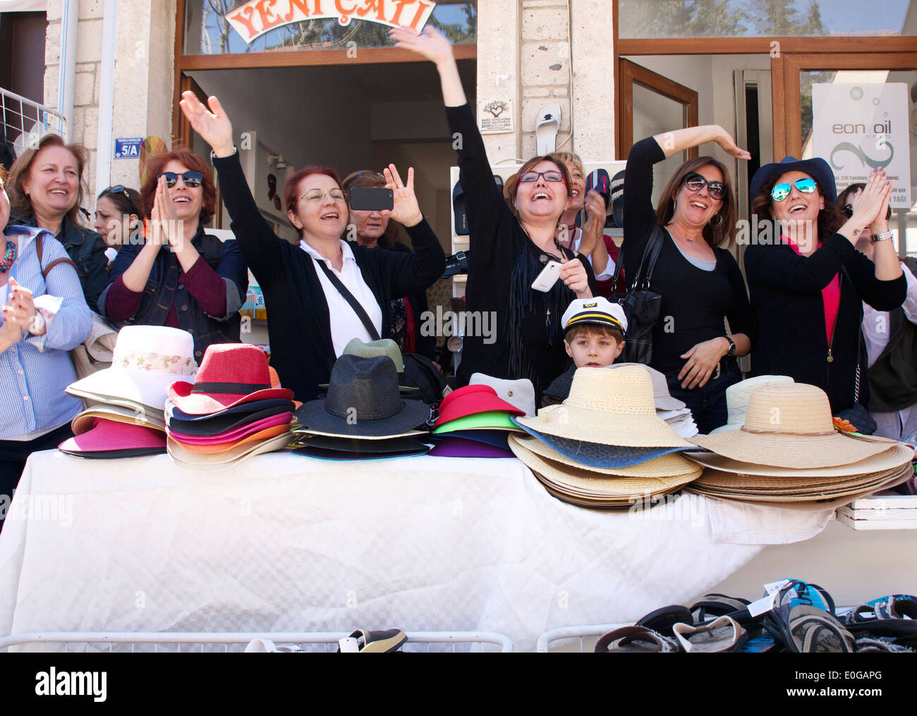 Turkish women waving to a procession in Alacati, Turkey Stock Photo