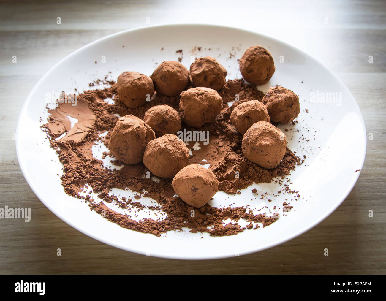 homemade chocolate truffles in cocoa powder on white plate Stock Photo