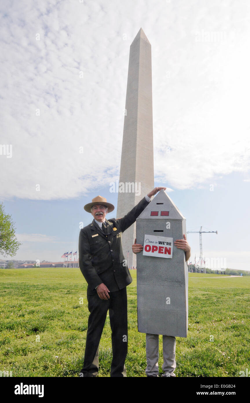 National Park Service Director Jonathan Jarvis jokes with a mascot dressed in costume during the reopening ceremony for The Washington Monument after a 2011 earthquake caused $15 million in damage May 12, 2014 in Washington, DC. Stock Photo