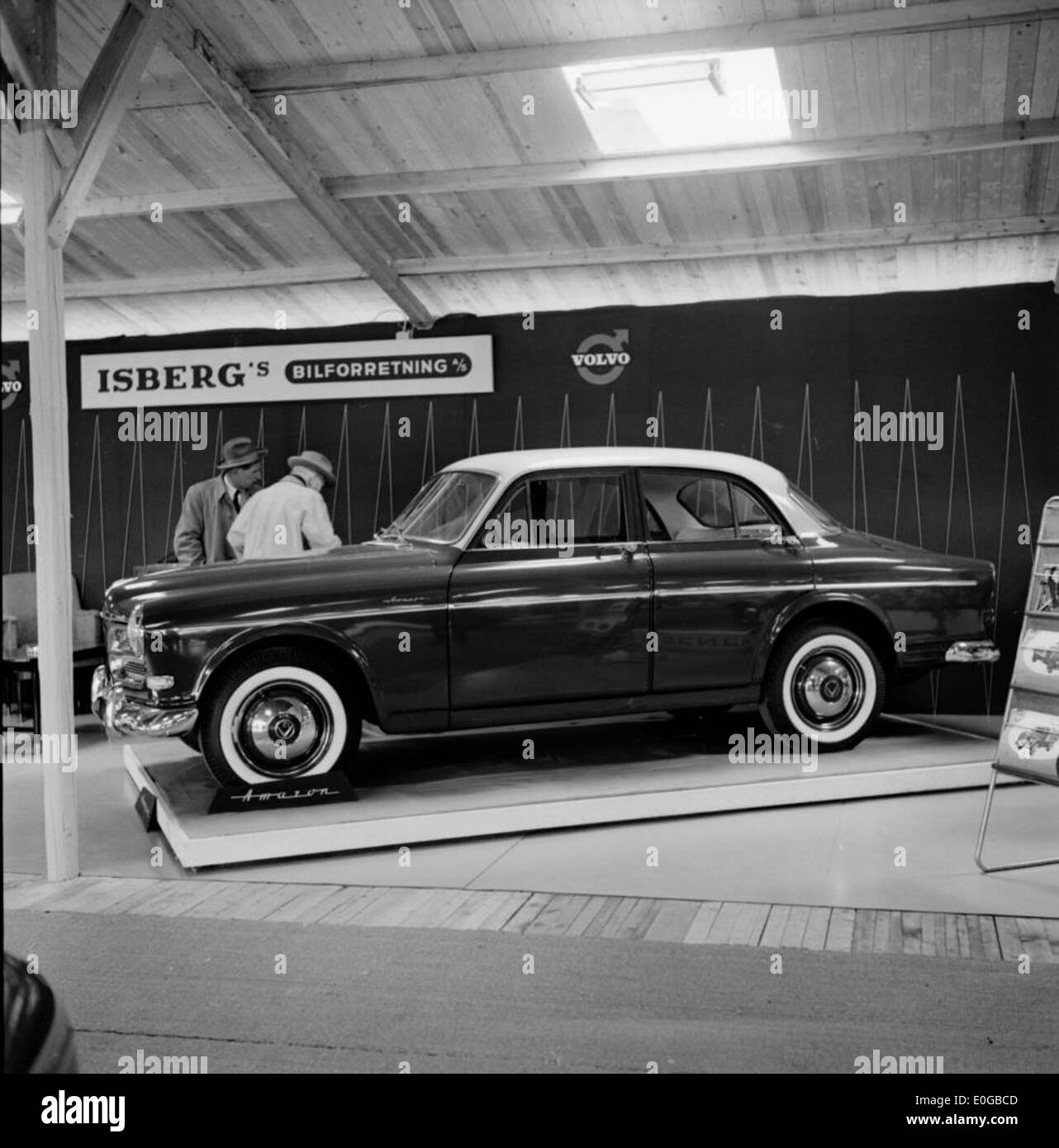 This image shows the Volvo Amazon at a motor show, emphasizing its design in the context of 2011's car exhibitions. It provides a view of the vehicle displayed in front of a scenic backdrop of trees and nature. Stock Photo