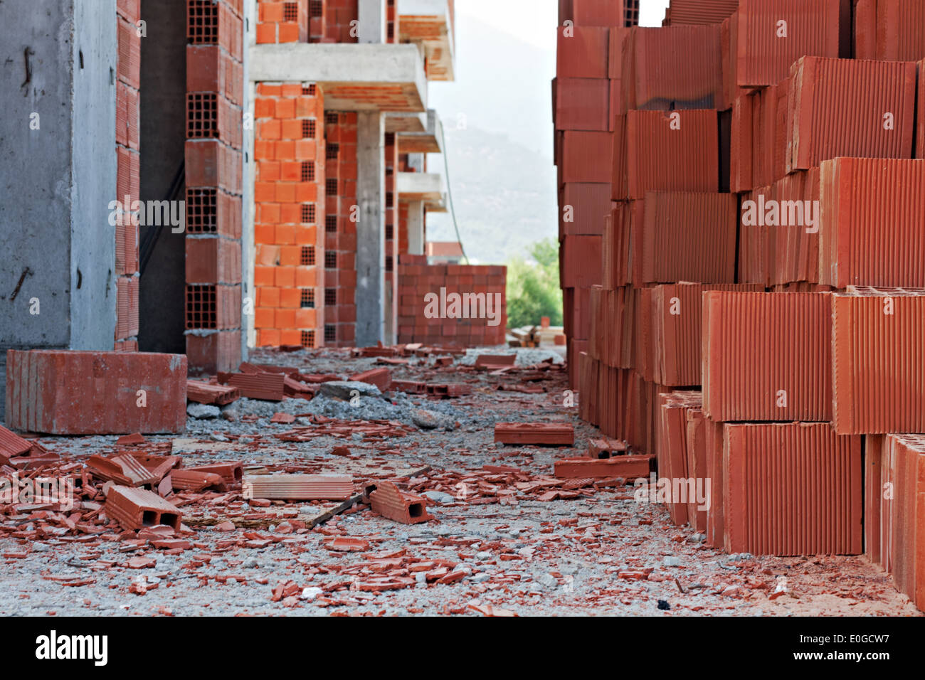 Stack of red building blocks on an untidy construction site Stock Photo -  Alamy