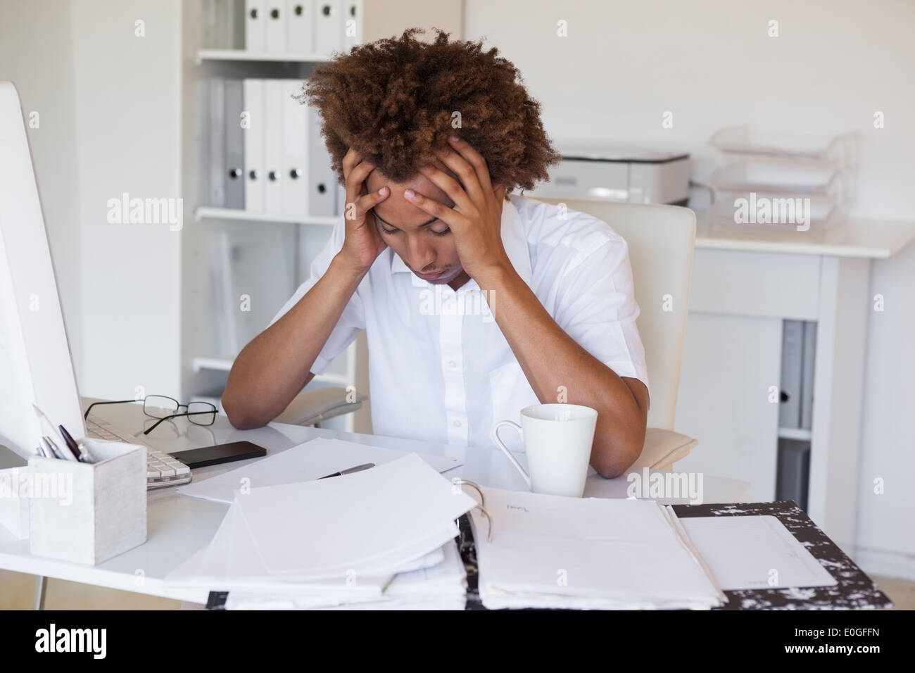 Casual stressed businessman with his head down at desk Stock Photo Alamy