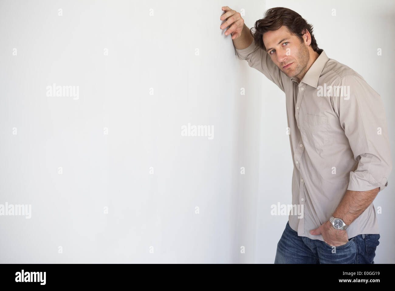 Casual worried businessman leaning on wall Stock Photo